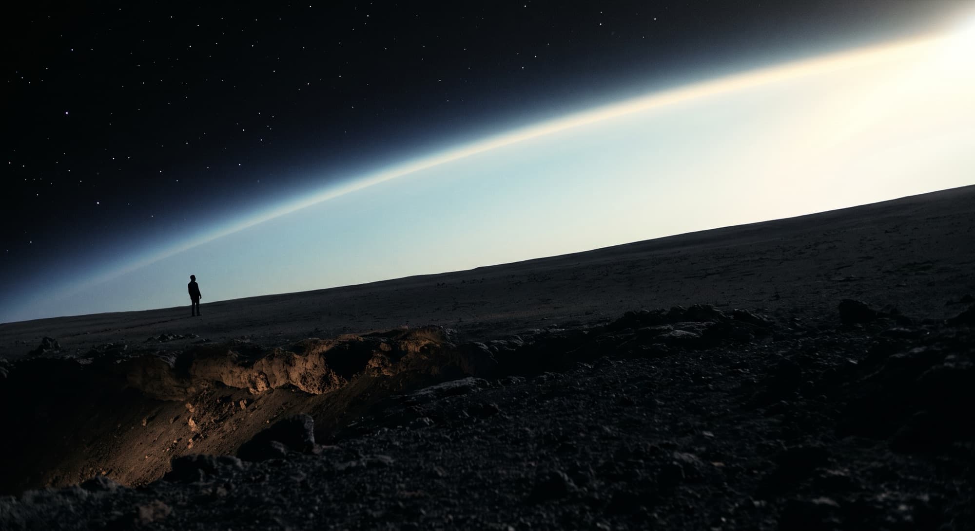 Uma pessoa sozinha na superfície escura de um planeta, olhando a orla luminosa da atmosfera contra o espaço.